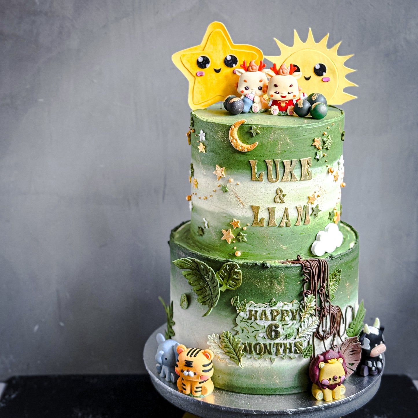 Slice of layered tier cake from Kaki Desserts featuring colorful frosting and decorative toppings on a white plate.