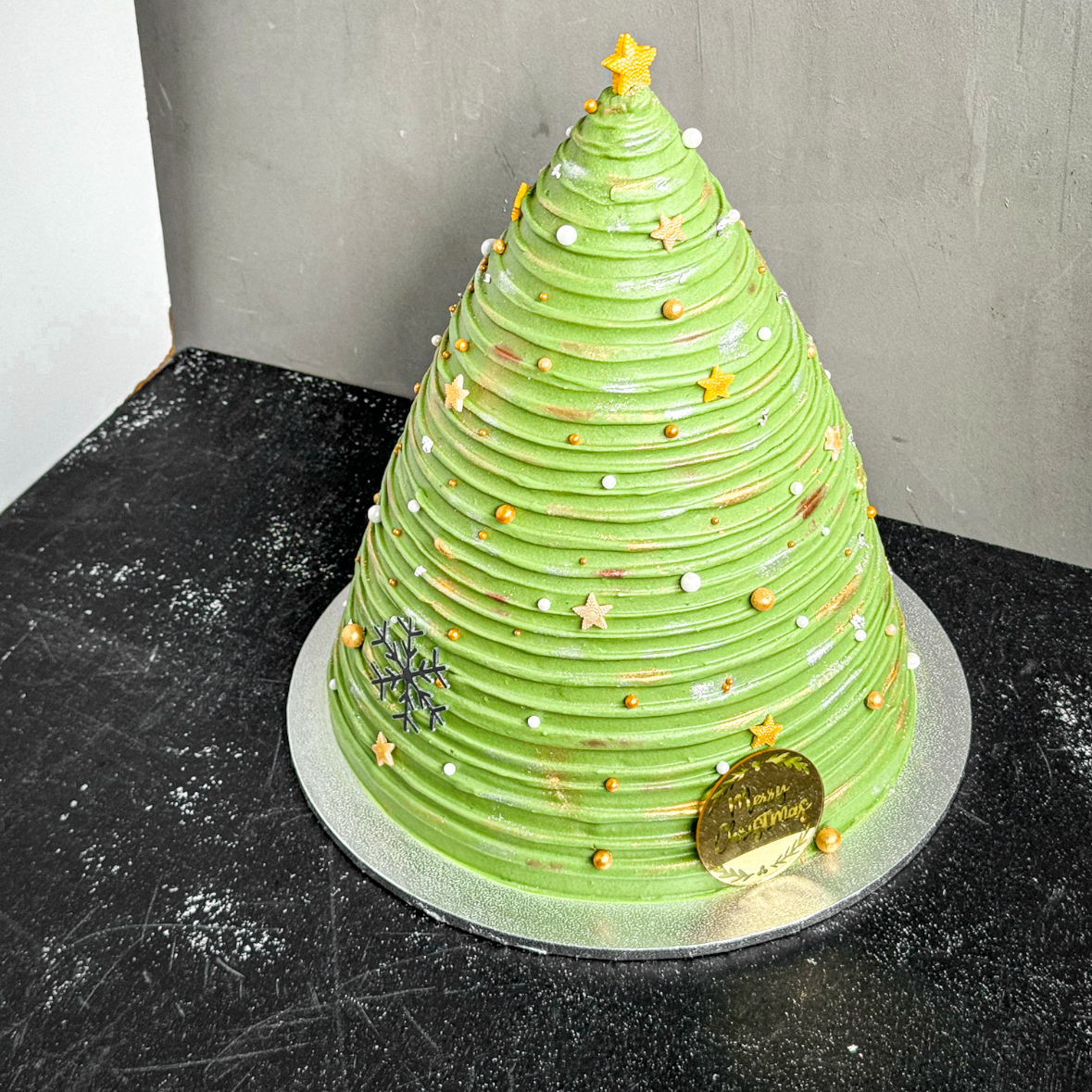 Decorative Christmas tree cake from Kaki Desserts with Gold stars and pearls perfect for the holiday