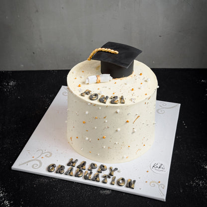 Decorative bespoke cake from Kaki Desserts with intricate icing and floral accents on a white cake stand.