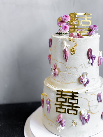 Layered tier cake from Kaki Desserts with colorful icing and decorative toppings, perfect for celebrations and special occasions.