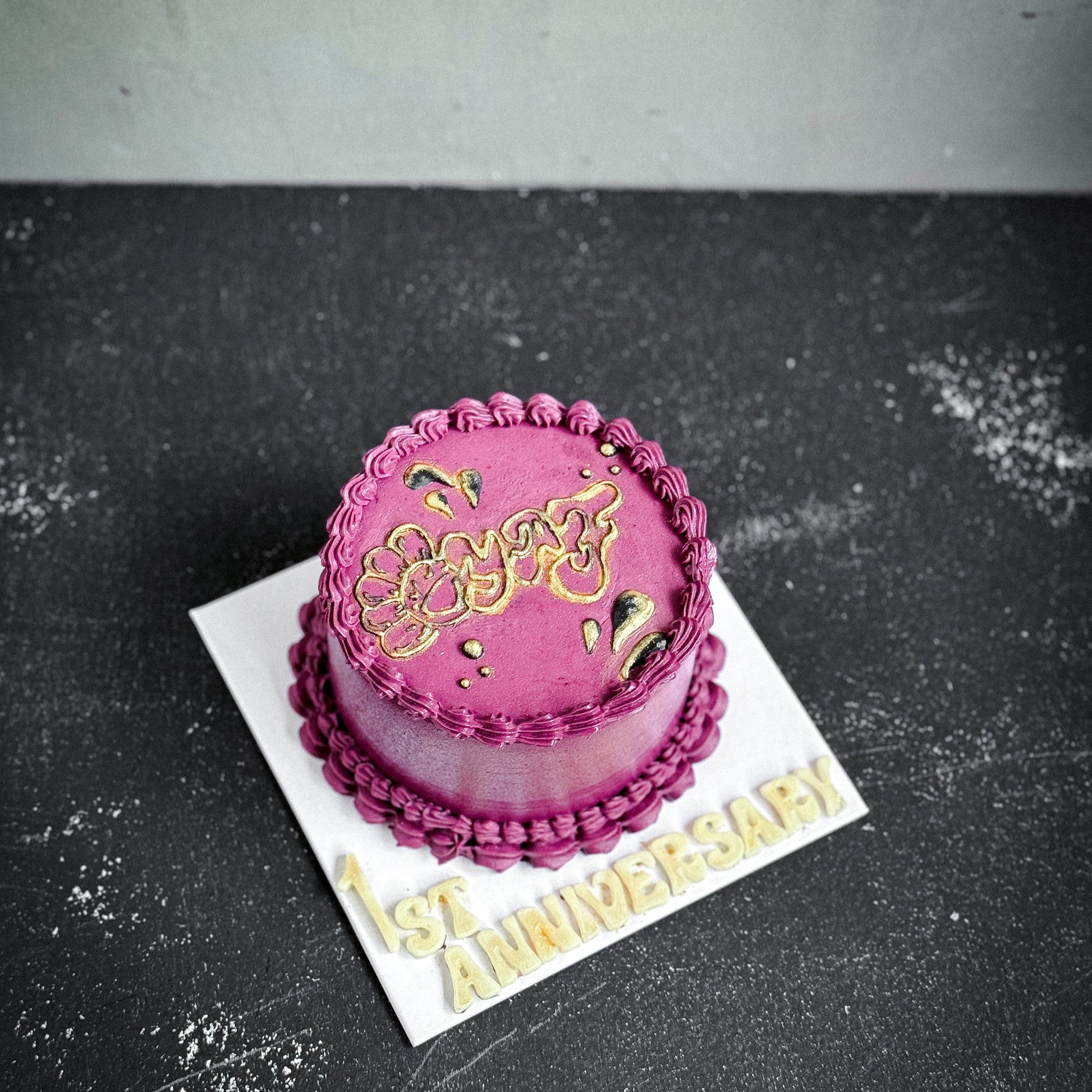 Elegant bespoke cake from Kaki Desserts with intricate floral decorations and smooth frosting, perfect for special occasions.