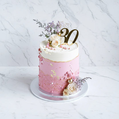 Pink floral 30th birthday cake from Kaki Desserts with marble design, decorated with fresh flowers and elegant details.