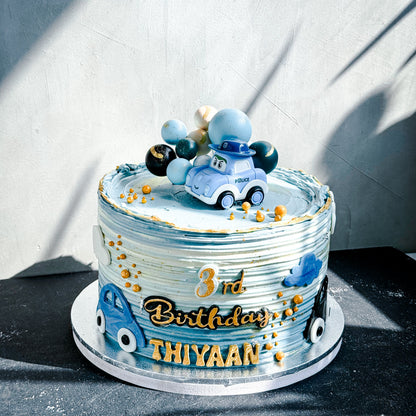 Decorative bespoke cake from Kaki Desserts with intricate icing details and elegant floral accents on a white cake stand.