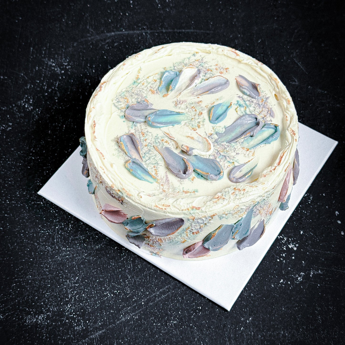 Decorative bespoke cake from Kaki Desserts featuring colorful floral icing and intricate piping design.