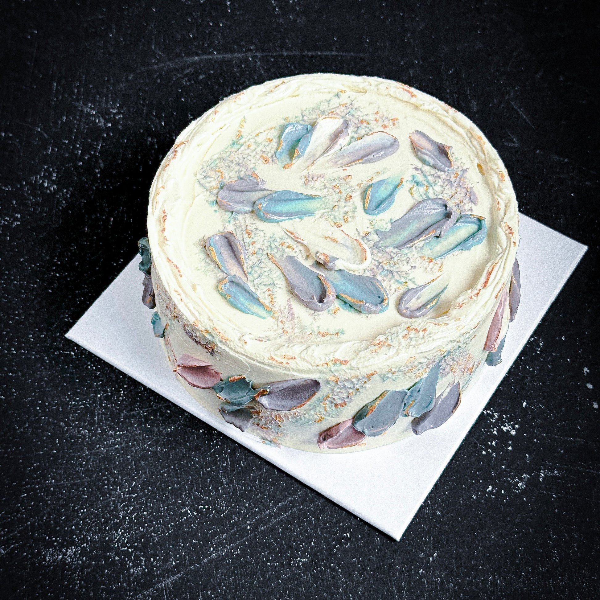 Decorative bespoke cake from Kaki Desserts featuring colorful floral icing and intricate piping design.