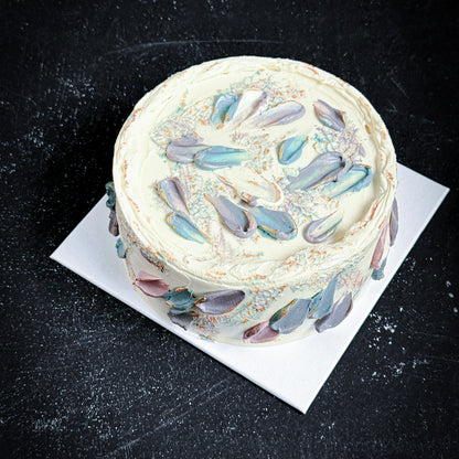 Decorative bespoke cake from Kaki Desserts featuring colorful floral icing and intricate piping design.