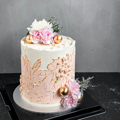 Elegant bespoke cake from Kaki Desserts with intricate floral decorations and smooth fondant finish.