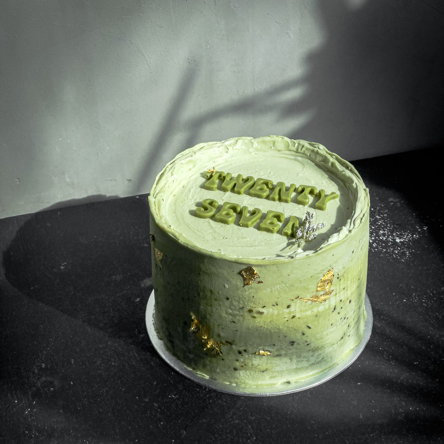 Assorted bespoke cakes from Kaki Desserts with colorful frosting and decorative toppings, displayed on a white platter.