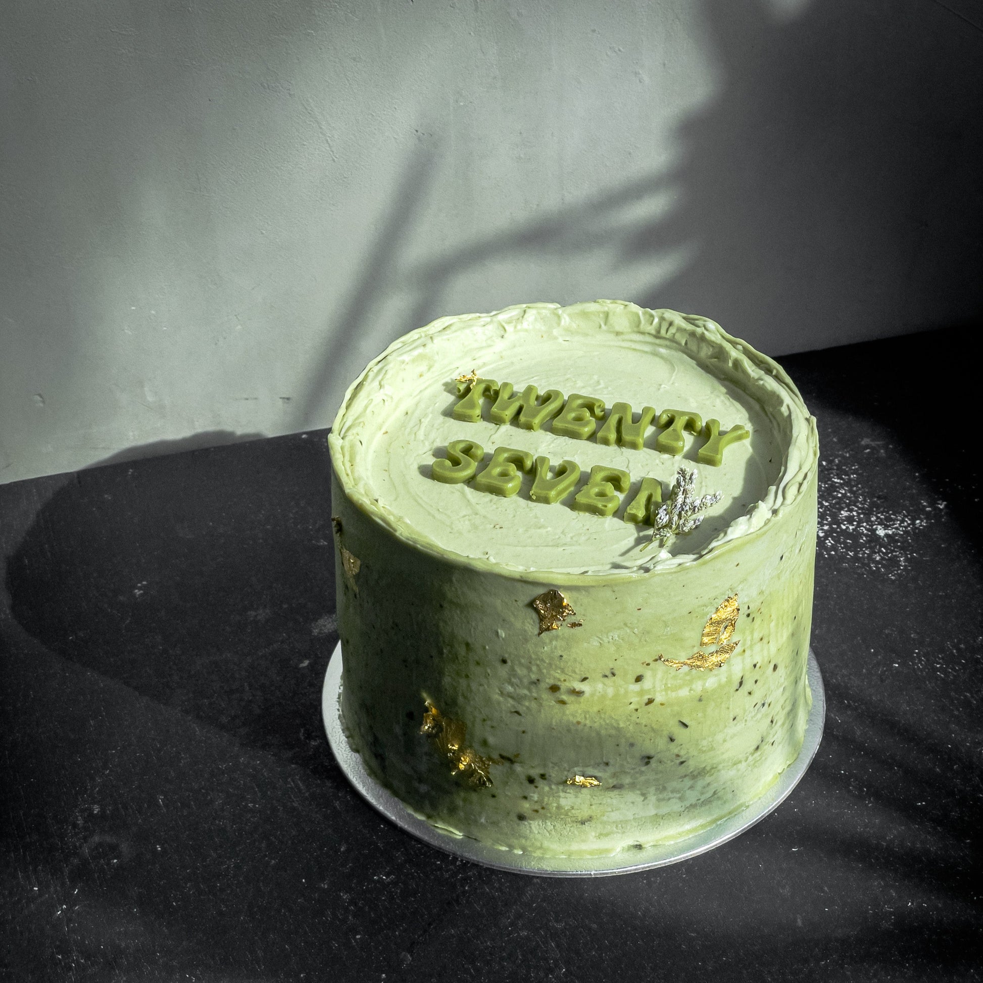 Assorted bespoke cakes from Kaki Desserts with colorful frosting and decorative toppings, displayed on a white platter.