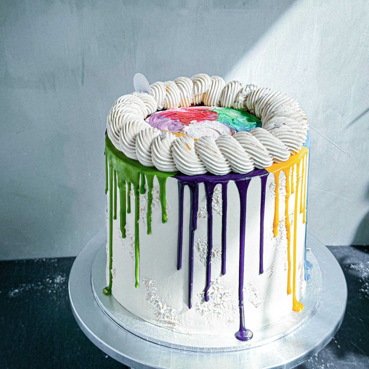 Decorative bespoke cake from Kaki Desserts with elegant frosting and intricate detailing, displayed on a cake stand.