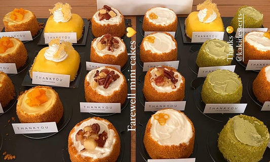 Assorted mini honey cakes from Kaki Desserts collection arranged on a plate with honey drizzle and decorative flowers.