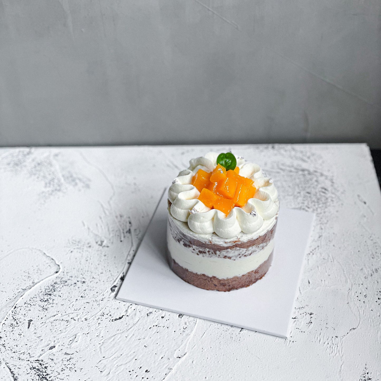 Elegant bespoke cake from Kaki Desserts with intricate floral decorations and smooth fondant finish.