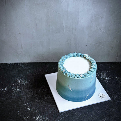 Decorative bespoke cake from Kaki Desserts with intricate icing and floral details for special occasions.