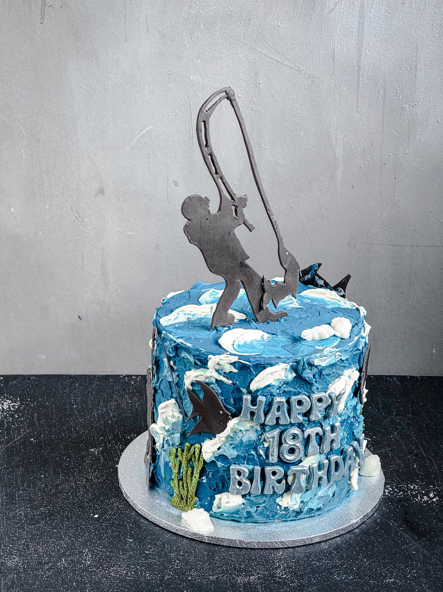 Assorted bespoke cakes from Kaki Desserts with colorful frosting and decorative toppings on a white platter.