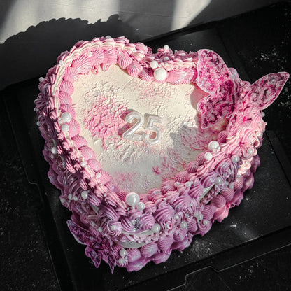 Decorative bespoke cake from Kaki Desserts with intricate icing details and colorful floral accents.