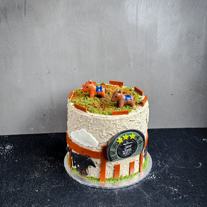 Decorative bespoke cake from Kaki Desserts with intricate frosting and colorful floral accents, displayed on a white cake stand.