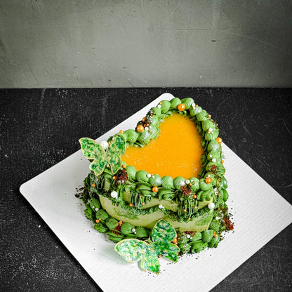 Assorted bespoke cakes from Kaki Desserts with elegant frosting and decorative toppings on a white platter.