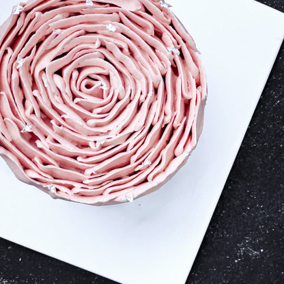 Velvet red velvet cake from Kaki Desserts with smooth cream cheese frosting and rich red color, topped with chocolate decor.