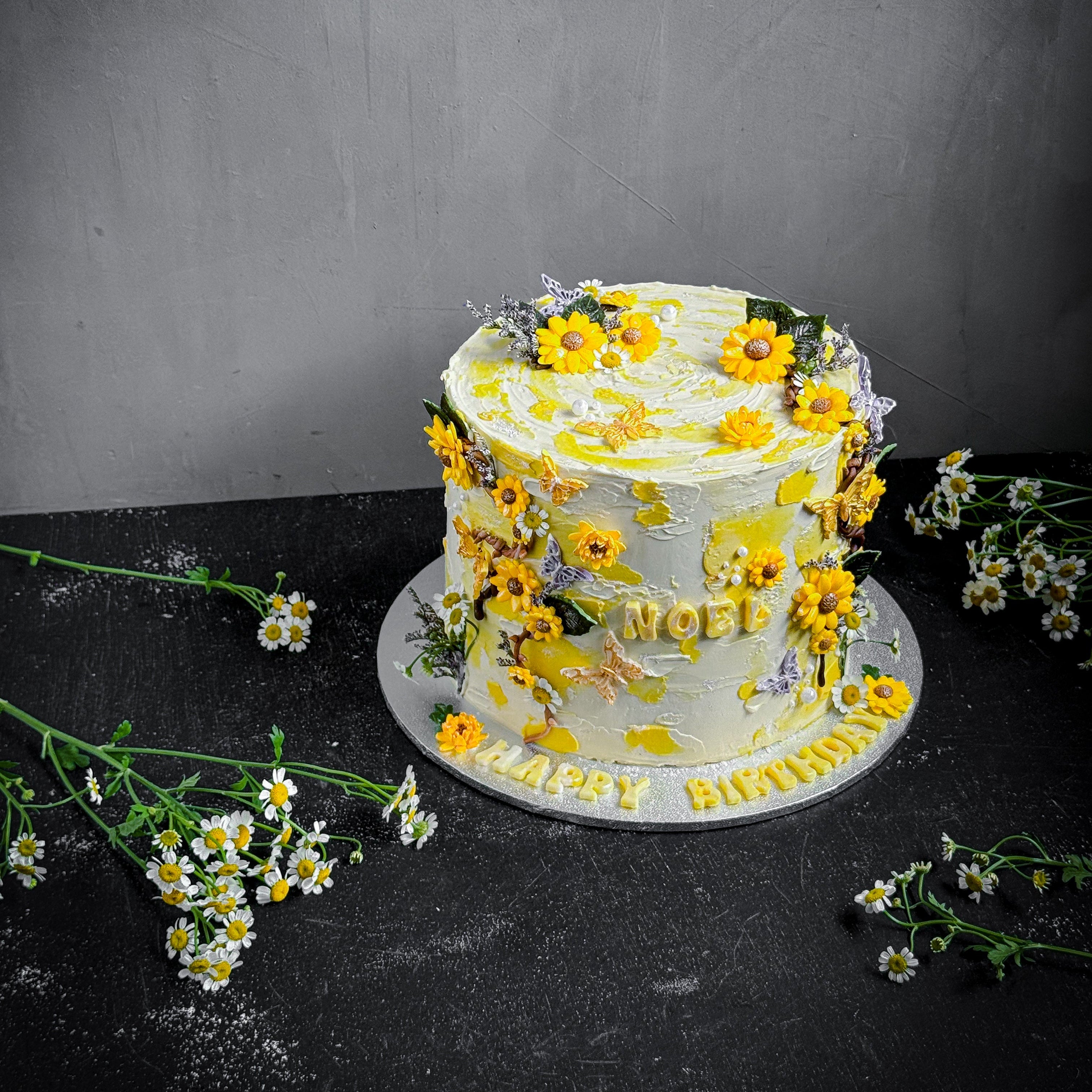 Decorative bespoke cake from Kaki Desserts with intricate icing details and elegant design, showcasing a beautifully crafted custom cake.