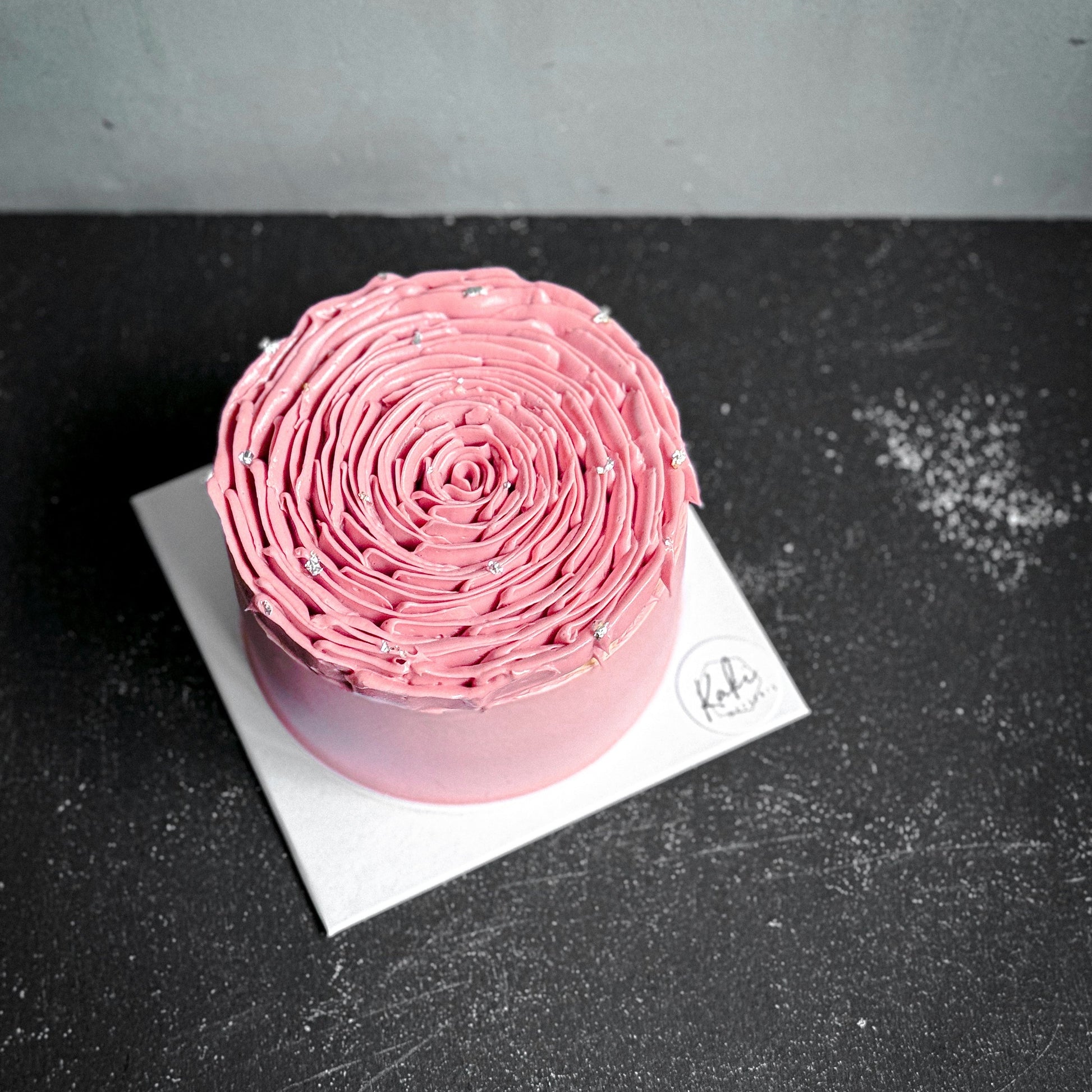 Velvet red velvet cake from Kaki Desserts with smooth frosting and rich layers, displayed on a plate.