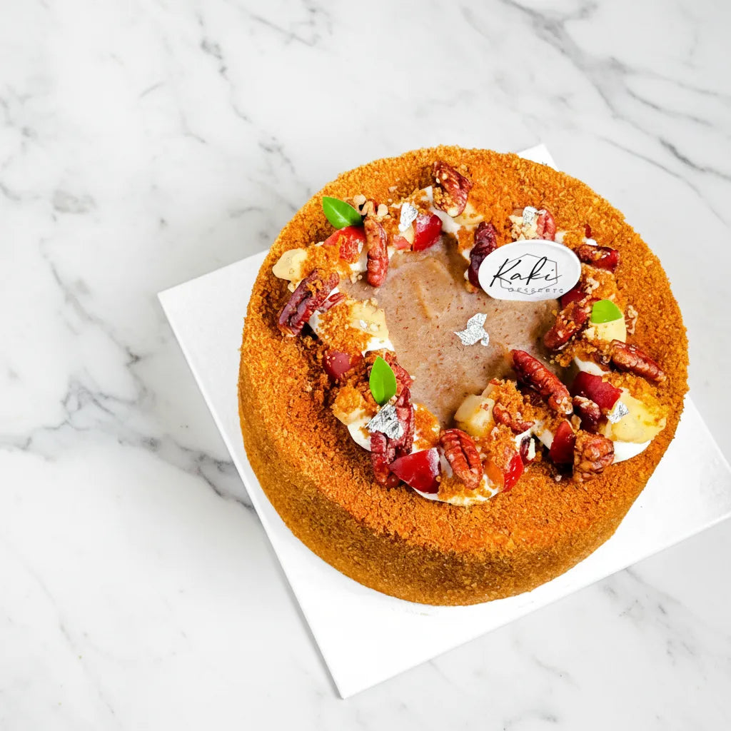 Apple Pecan cake from Kaki Desserts, sugar-free dessert with fresh apple slices and pecans on top, served on a white plate.