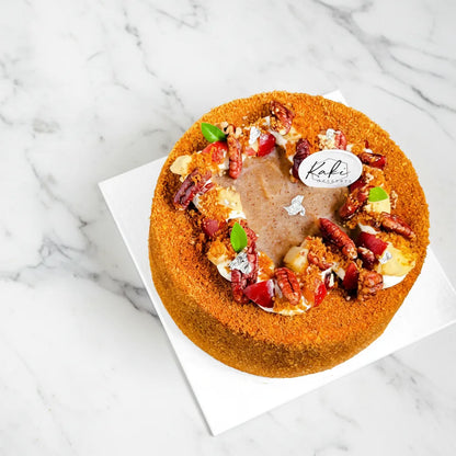 Apple Pecan cake from Kaki Desserts, sugar-free dessert with fresh apple slices and pecans on top, served on a white plate.