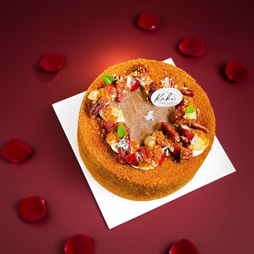 Slice of Kaki Desserts Apple Pecan cake with apple slices and pecans on Valentine's themed plate, side view.