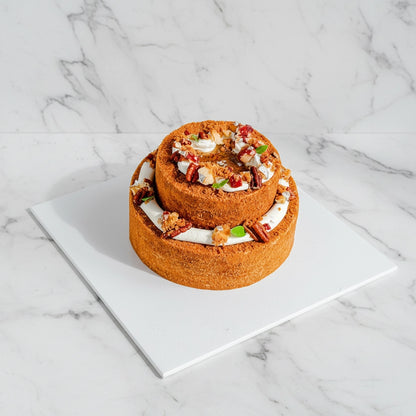 Slice of Apple Pecan dessert from Kaki Desserts with marble pattern, featuring apple and pecan toppings on a white plate.