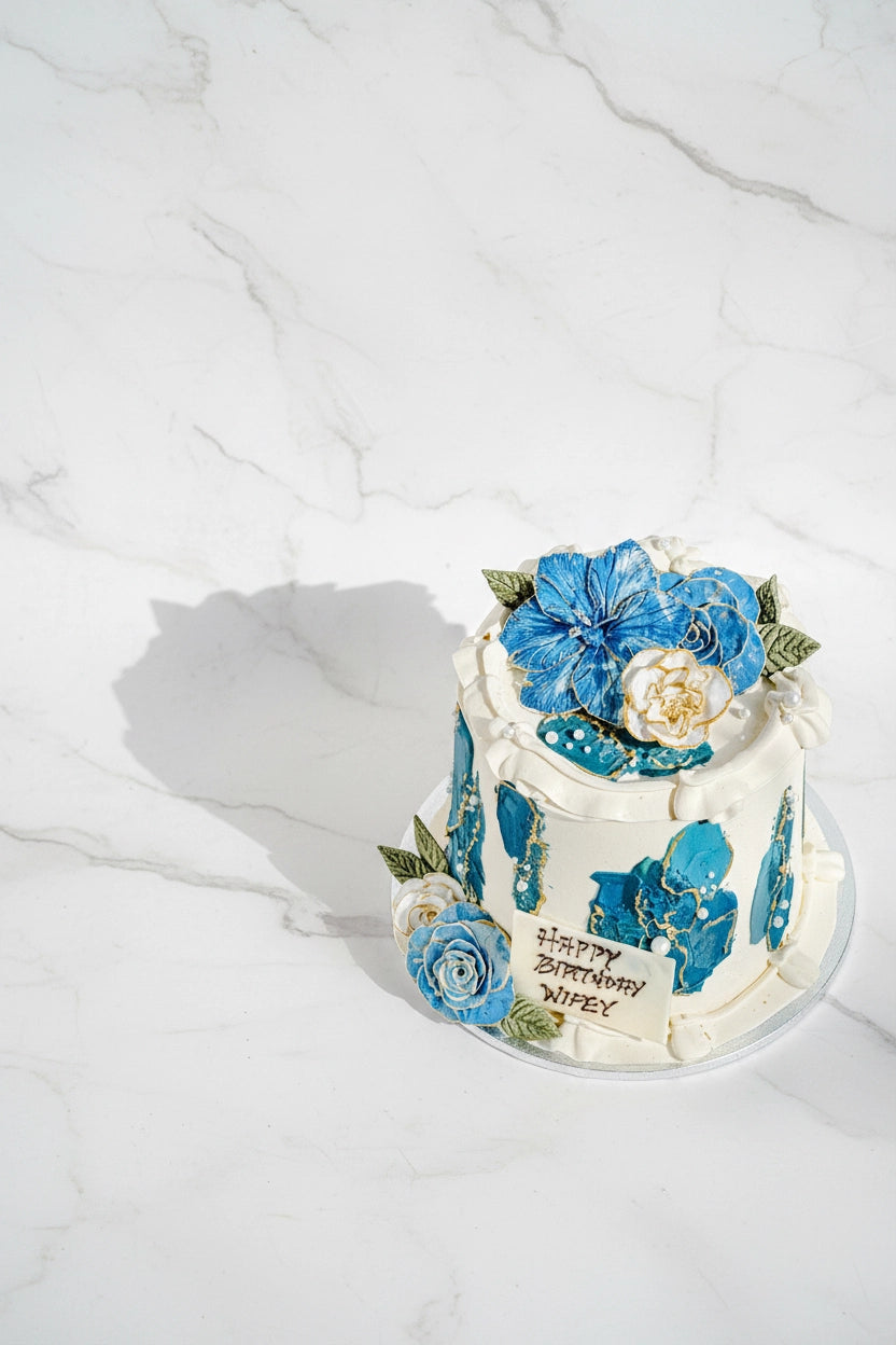 Blue floral marble cake from Kaki Desserts featuring elegant floral designs and marble pattern on a bespoke cake.