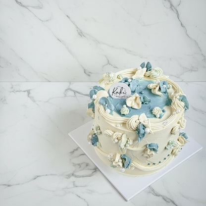 Blue Lambeth cake with marble frosting by Kaki Desserts, showcasing a beautifully designed bespoke cake with intricate patterns.
