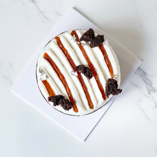 Slice of Goji Chocolate gluten-free cake with chocolate and caramel layers from Kaki Desserts, topped with fresh goji berries.