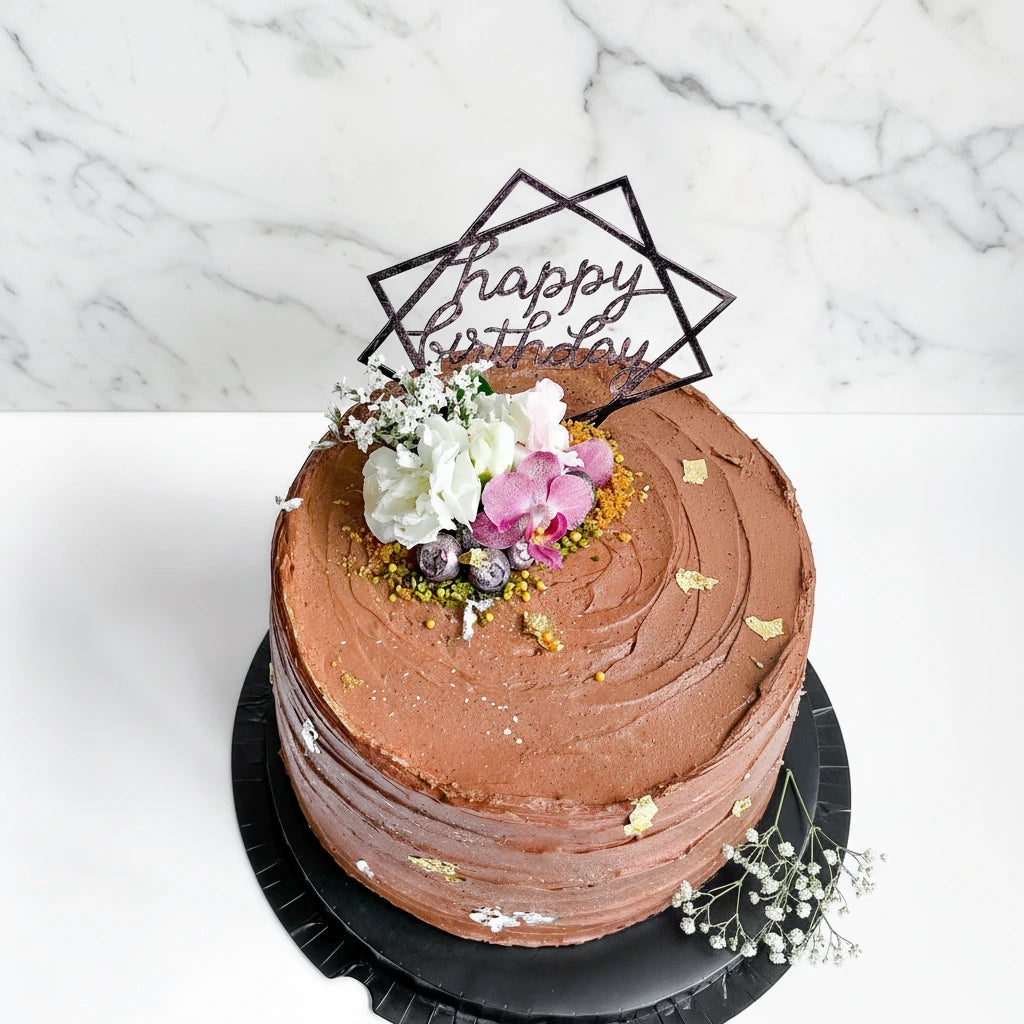 Chocolate ganache cake with a marble design from Kaki Desserts, featuring smooth, glossy chocolate topping and elegant marbled pattern.