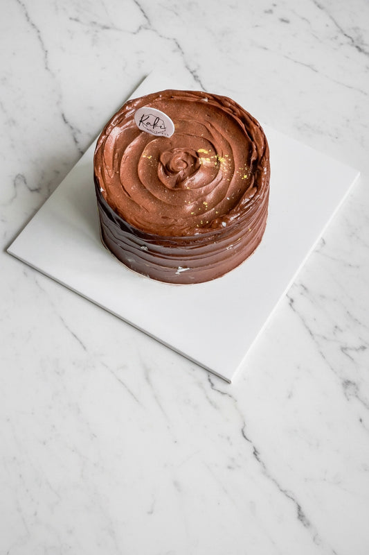 Full view of Kaki Desserts Devil's Cake featuring a rich, marble chocolate and vanilla layered cake with smooth frosting.