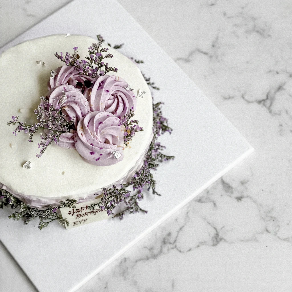 Decorative marble birthday cake from Kaki Desserts with colorful frosting and festive design, perfect for celebrating Evy's special day.