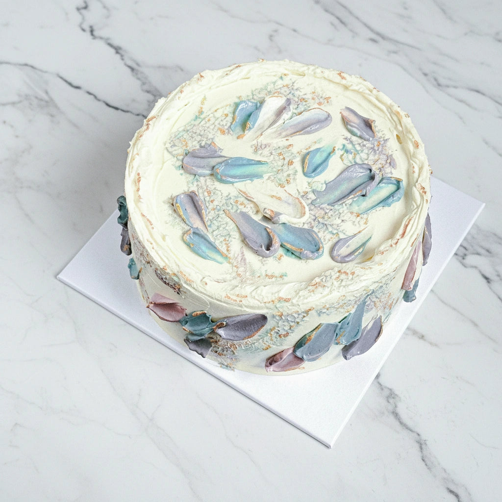 Iridescent petal cake by Kaki Desserts featuring a marble design with shimmering, colorful petals on a smooth cake surface.
