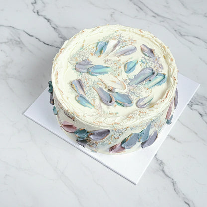 Iridescent petal cake by Kaki Desserts featuring a marble design with shimmering, colorful petals on a smooth cake surface.