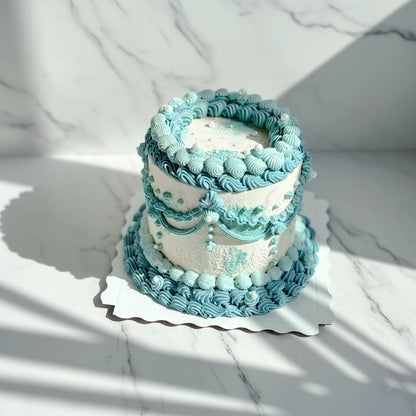 Marble ocean-wave design on a bespoke cake by Kaki Desserts, showcasing intricate blue and white marbling art.