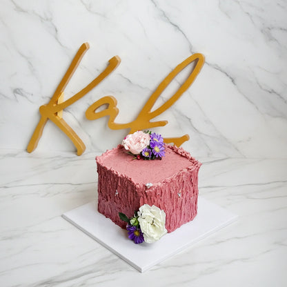 Pink floral marble cake by Kaki Desserts featuring elegant floral decorations and a marbleized pink and white frosting design.