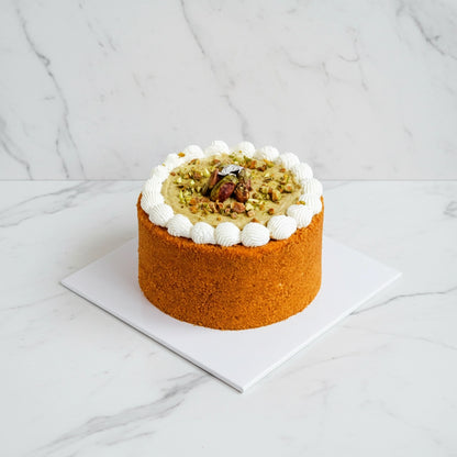 Slices of Kaki Desserts pistachio honey cake with pistachio pieces and honey glaze on top, showcasing a sugar-free dessert option.