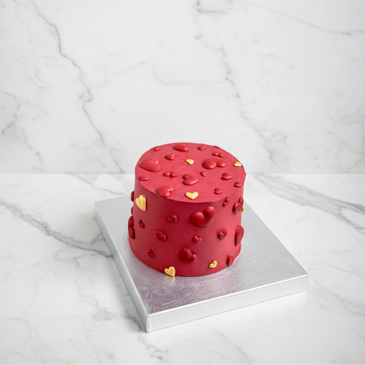 Marble red heart-shaped cake by Kaki Desserts featuring smooth red marbled frosting and elegant design.
