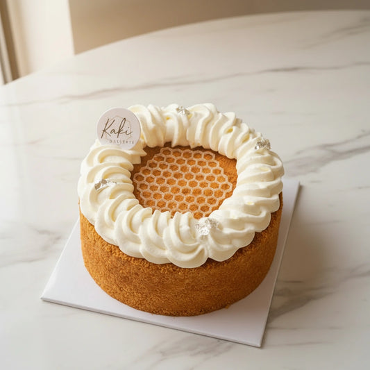 Kaki Desserts Honeybee signature honey cake made with refined, sugar-free ingredients, topped with honey and served on a plate.