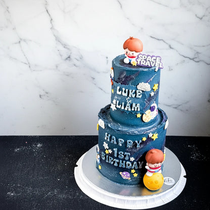 Marble space travel-themed cake from Kaki Desserts with colorful space and planet decorations on a tiered cake.