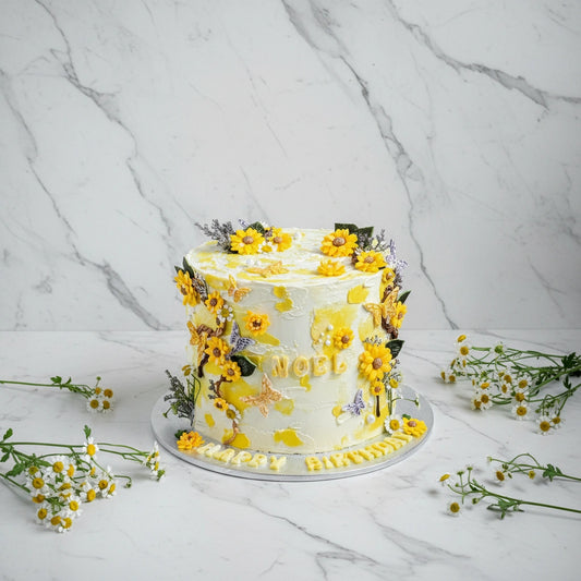 Marble sunflower cake from Kaki Desserts featuring a marbled design with sunflower-shaped decorations on top.