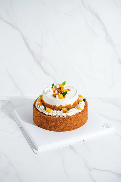 Two-tier mango float cake by Kaki Desserts, featuring layers of fresh mango and creamy dessert in a polished presentation.