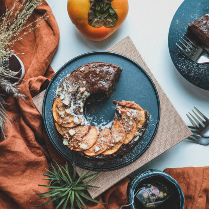 Chocolate Bundt cake from Kaki Desserts with a rich glaze and decorative toppings, displayed on a plate.