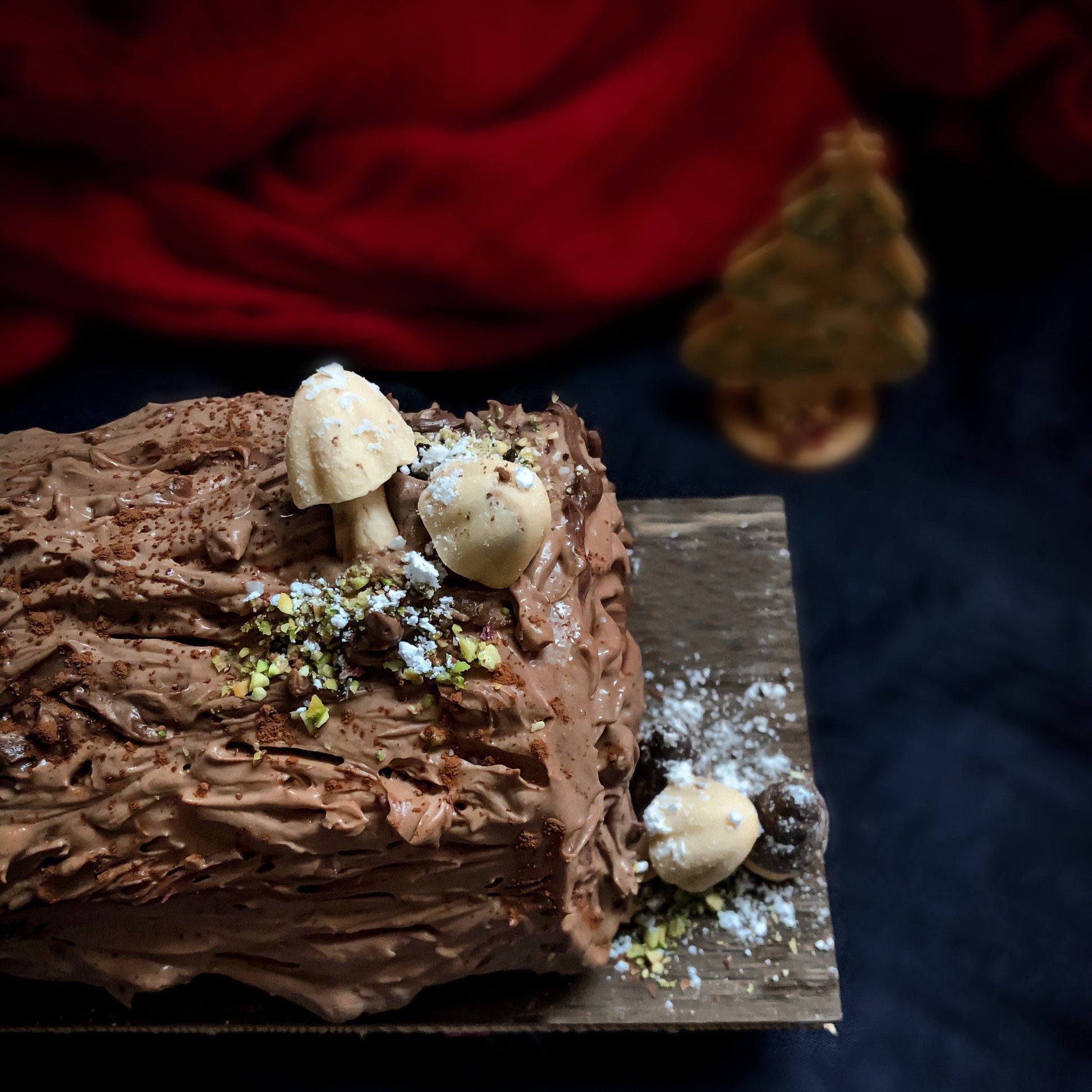 Chocolate cherry log cake from Kaki Desserts featuring rich chocolate and cherry filling with a decorative frosting topping.